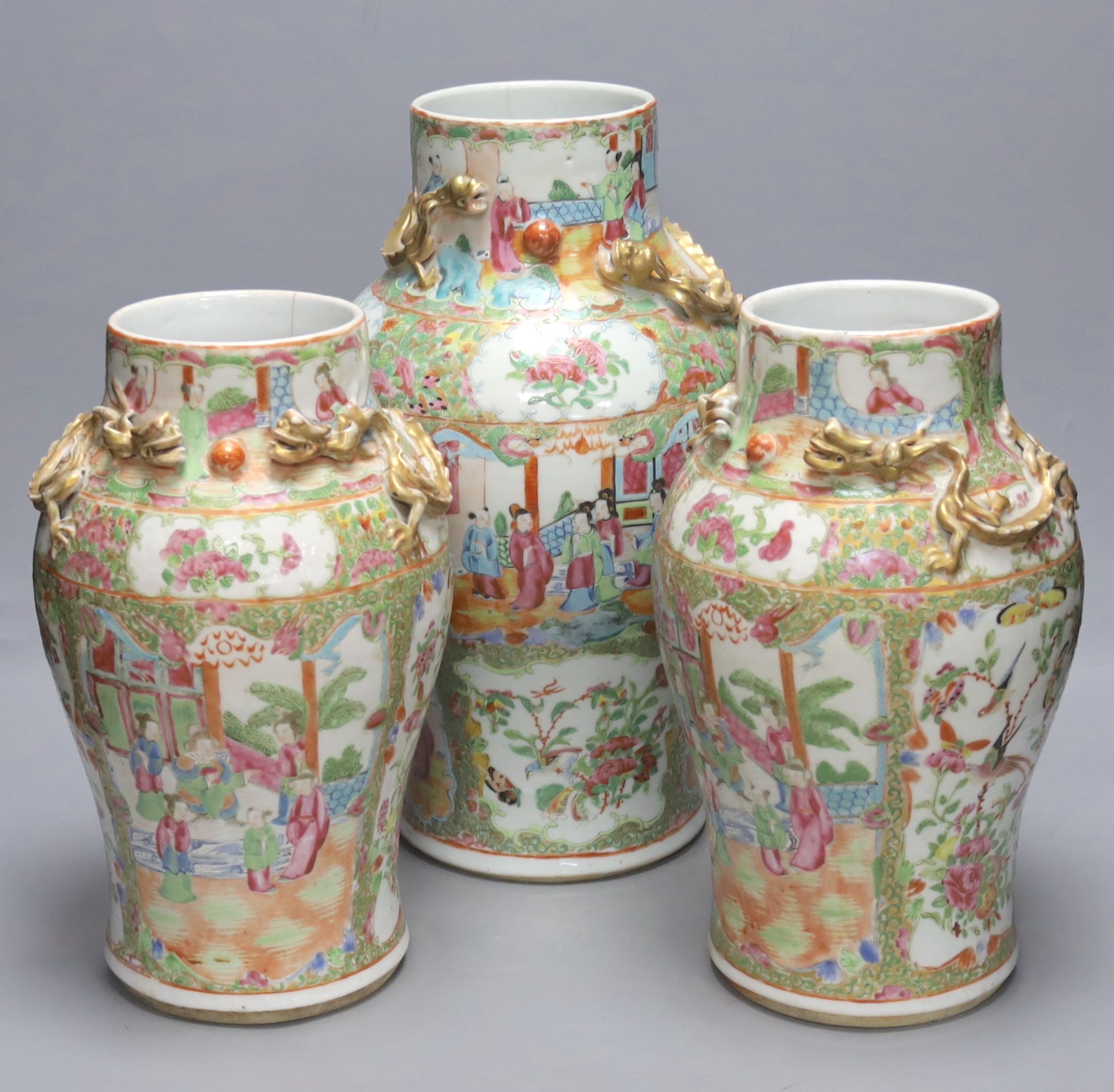 A pair of 19th century Chinese famille rose vases, height 30.5cm and a similar larger vase, 37.5cm (3)